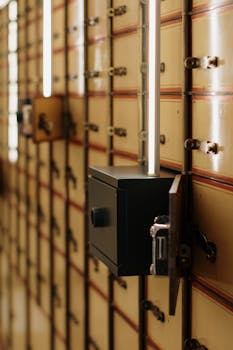 Close-up of vintage safety deposit boxes with one open, revealing secure interiors.